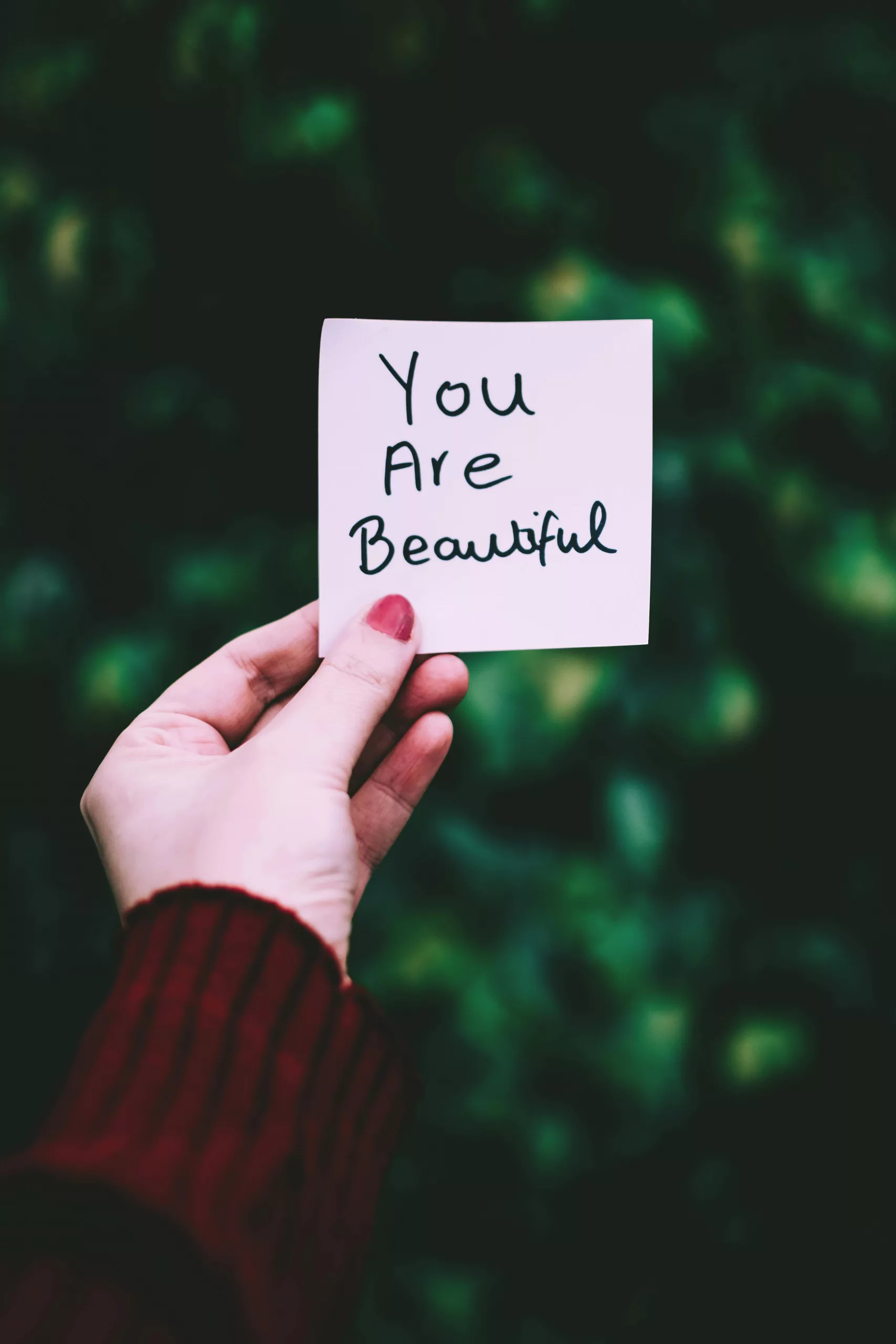 main d'une femme qui lit  une jolie phrase : "you are beautiful". 
